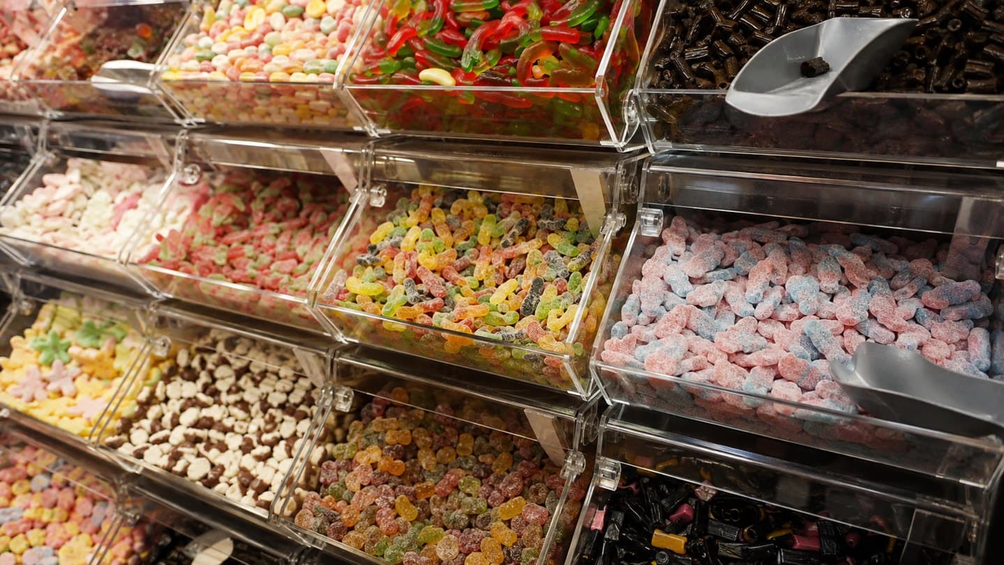 A colorful wall of Swedish pick-and-mix candy bins.